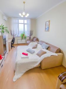 ein großes Bett im Wohnzimmer mit Sofa in der Unterkunft Rent Kiev Apartment 2 min metro Chernihivska in Kiew