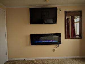 a wall with a flat screen tv and a fire place at Stroll to Slopes, Village Area, Ski in-out MtLodge 333 in Snowshoe
