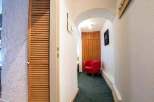 przedpokój z czerwonym krzesłem w pokoju w obiekcie Apartment Peacock - Steinbock Lodges w mieście Zell am See +21 zdjęć