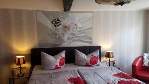 a bedroom with a bed with red and white pillows at Ratsstübchen in Wernigerode