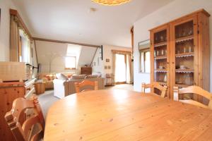 eine Küche und ein Wohnzimmer mit einem Holztisch und Stühlen in der Unterkunft WIEDWEG GOLD in Wiedweg