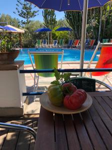 a plate of tomatoes sitting on a table next to a pool at Villa Eva in Anacapri