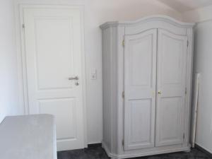 Habitación blanca con armario y puerta en Ferienwohnung-England, en Nordstrand
