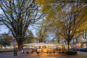 a group of tables and umbrellas on a city street at BOUTIQUE Hotel by Continental Park in Luzern