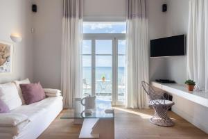 ein Wohnzimmer mit einem weißen Sofa und Meerblick in der Unterkunft Dexamenes Seaside Hotel in Kourouta