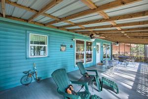 a woman is sitting in chairs on the porch of a house at Cozy Cottage on Lake O The Pines with Lake Views! in Avinger