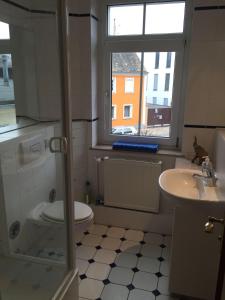 a bathroom with a toilet and a sink and a window at Kleine-Mietidee in Markranstädt