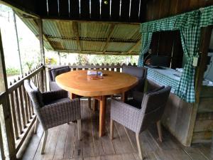 une table et des chaises en bois sur une terrasse dans l'établissement Finca Sueno de Osa, à Puerto Jiménez