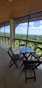 d'une table et de deux chaises sur un balcon avec vue. dans l'établissement Flat Grande em Hotel Fazenda Monte Castelo - Gravatá - Sairé, à Gravatá