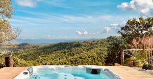 a jacuzzi tub sitting on a deck with a view at Relais Il Pozzeto in Anghiari