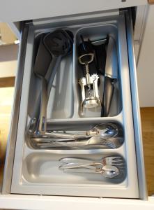 a metal drawer filled with utensils in a kitchen at München-Riem my room Apartment an der Messe in Munich