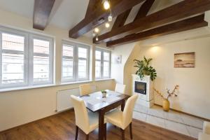 a dining room with a table and chairs and a fireplace at Gdańskie Apartamenty - Apartamenty na Świetego Ducha z 2 sypialniami in Gdańsk