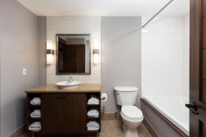 La salle de bains est pourvue de toilettes, d'un lavabo et d'une baignoire. dans l'établissement Ermitage du Lac, à Mont-Tremblant