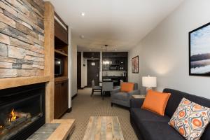 a living room with a couch and a fireplace at Ermitage du Lac in Mont-Tremblant