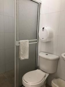 a small bathroom with a toilet and a shower at Hotel Balcones de Bocagrande in Cartagena de Indias