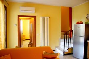 ein Wohnzimmer mit gelben Wänden und einem weißen Kühlschrank in der Unterkunft Villa Sole in Lido di Scacchi