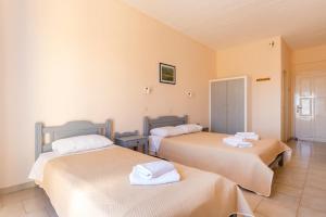 a room with two beds with towels on them at Vanas Apartments in Spetses