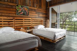 沙璜的住宿－Beu Ceubeh Cottage Sabang，木墙客房的两张床