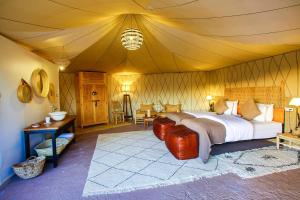 a bedroom with a large bed in a tent at Madu Luxury Desert Camp in Merzouga