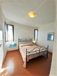 a bedroom with a bed and two windows at Terza Spiaggia & La Filasca - Apartments in Golfo Aranci