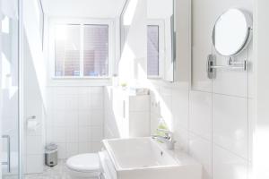 a white bathroom with a sink and a toilet at Frau-Clara-Haus-Ecke-4 in Eckernförde