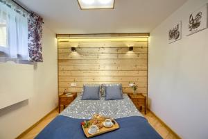 a bedroom with a blue bed with a wooden headboard at Apartament Uroczy Zakątek in Tylicz
