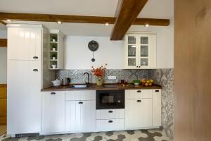 a kitchen with white cabinets and a counter top at Apartament Uroczy Zakątek in Tylicz