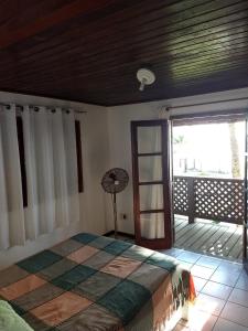 una camera con un letto in una stanza con balcone di Condomínio Terra Pura a Ilhéus