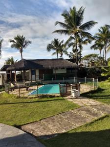 una casa con piscina e palme di Condomínio Terra Pura a Ilhéus