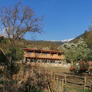 een houten huis met een hek ervoor bij NEUE Ferienwohnungen auf dem Gebreitnerhof, Urlaub auf dem Bauernhof in Bressanone