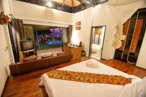 ein Schlafzimmer mit einem Bett und einem Fernseher darin in der Unterkunft LaLaanta Hideaway Resort in Ko Lanta