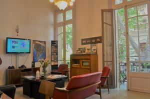 a waiting room with chairs and a tv in a room at Reina Madre Hostel in Buenos Aires