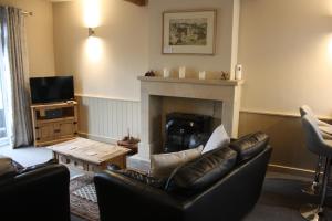 a living room with a couch and a fireplace at Squirrel cottage in Cowling
