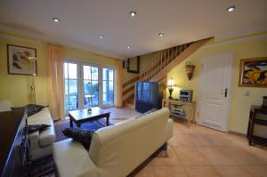 een woonkamer met een witte bank en een tv bij Reet-Eckhaus-17f-Moosbeere in Gager