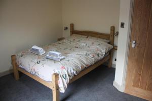 a bed with two towels on it in a bedroom at Squirrel cottage in Cowling