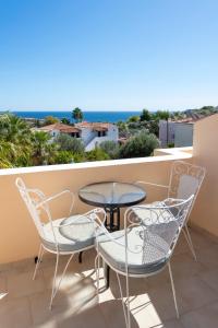 a balcony with a table and chairs and the ocean at Vanas Apartments in Spetses