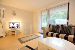 sala de estar con sofá y TV en App-Kuestenperle, en Westerland