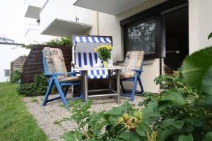 2 sillas azules y una mesa en el patio en App-Kuestenperle, en Westerland
