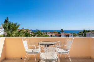a table and chairs on a balcony with a view of the ocean at Vanas Apartments in Spetses