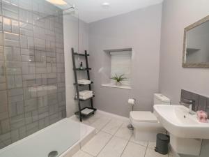 a white bathroom with a tub and a sink and a toilet at 3 Old Hall Cottages in Bakewell +16 photos