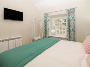 - une chambre avec un lit et une télévision à écran plat dans l'établissement 3 Old Hall Cottages, à Bakewell