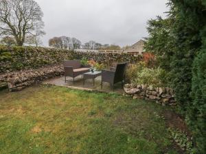 two chairs and a table in a garden at 3 Old Hall Cottages in Bakewell