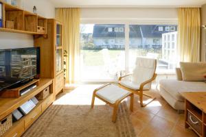 sala de estar con sofá y TV en Haus-Carola-App-11-Sylter-Seestern en Wenningstedt