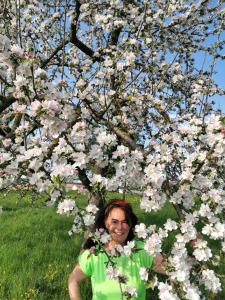 un hombre parado frente a un árbol con flores en Ferienwohnung im Turm Bellevue mit 3 Schlafzimmern, en Sachsenheim