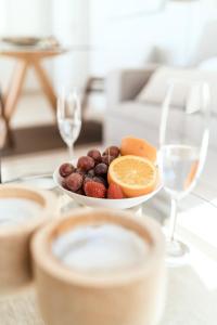 a plate of fruit on a table with wine glasses at Polo Apartments 8B in Marbella