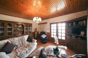 a living room with a zebra couch and a wooden ceiling at Casa Rural do Salgueirinho in Santo Tirso