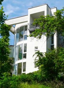 um edifício branco com uma varanda ao lado em Ferienwohnung im Turm Bellevue mit 3 Schlafzimmern em Sachsenheim