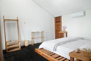 a bedroom with a bed and a wooden table at Beu Ceubeh Cottage - Family Room in Sabong