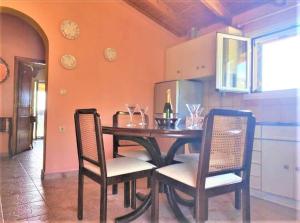 a dining room table and chairs in a kitchen at TETRAKTYS ESTATE ( ΑΗΡ ) in Halikounas