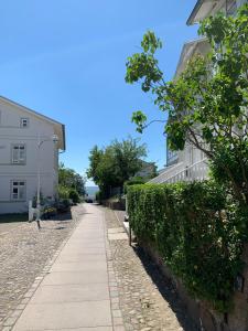 ザスニッツにあるVilla-Rosengarten-Ferienwohnung-Baumhaus-mit-Seeblickの白い建物前の歩道